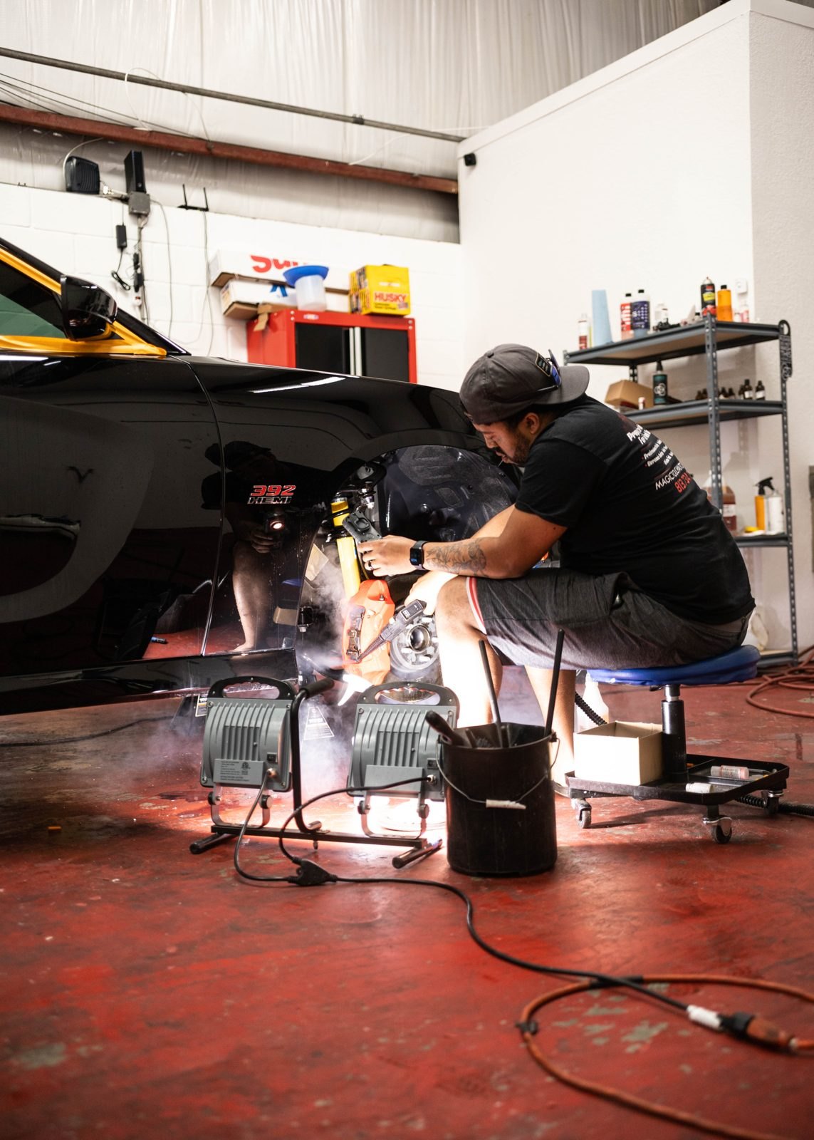 Our founder machine-polishing a black car in the Obsidian Detail Studios bay